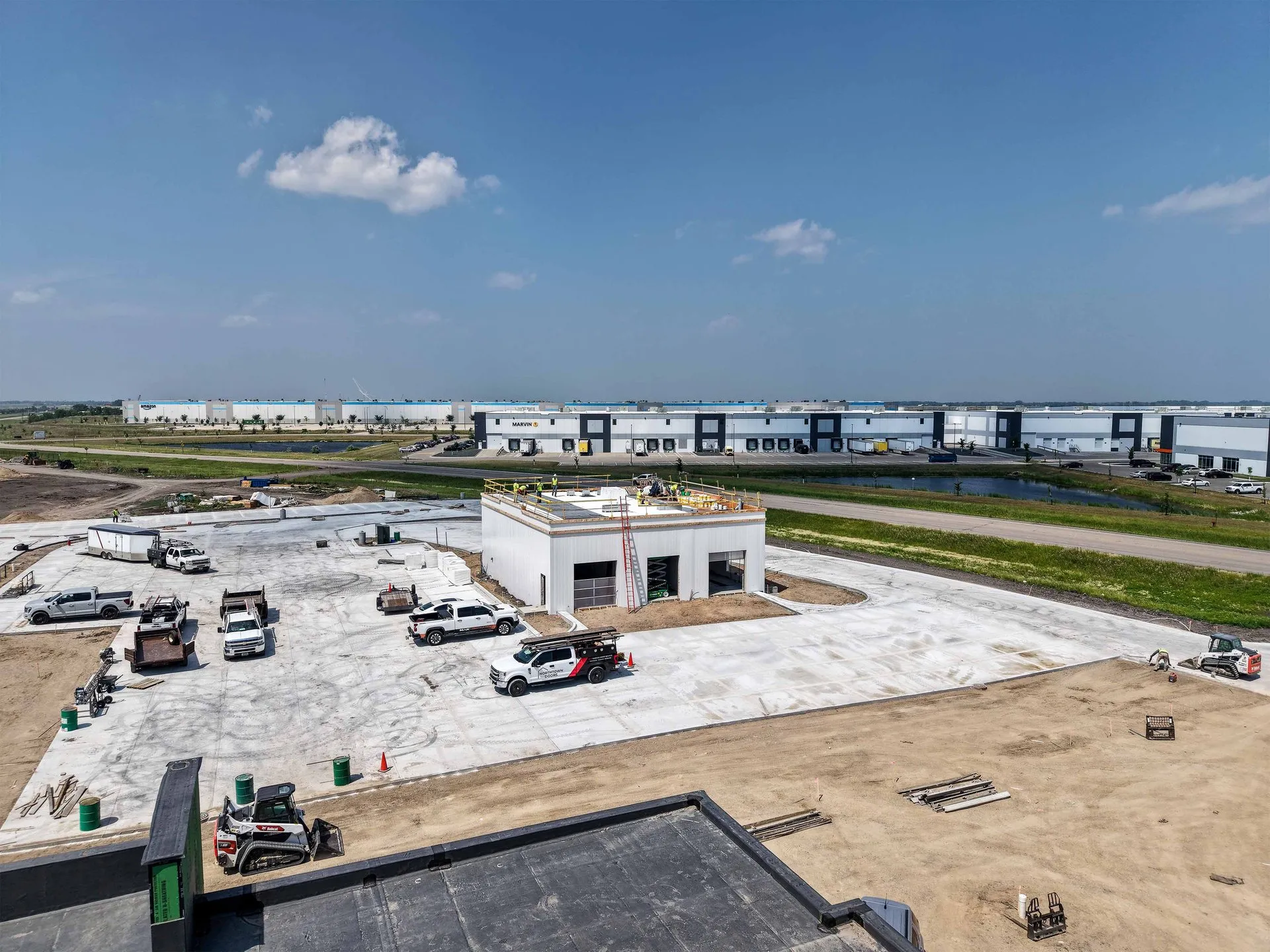 Aerial view of the Northdale Oil car wash building under construction in north Fargo, North Dakota, with the Marvin and Amazon facilities across the road.