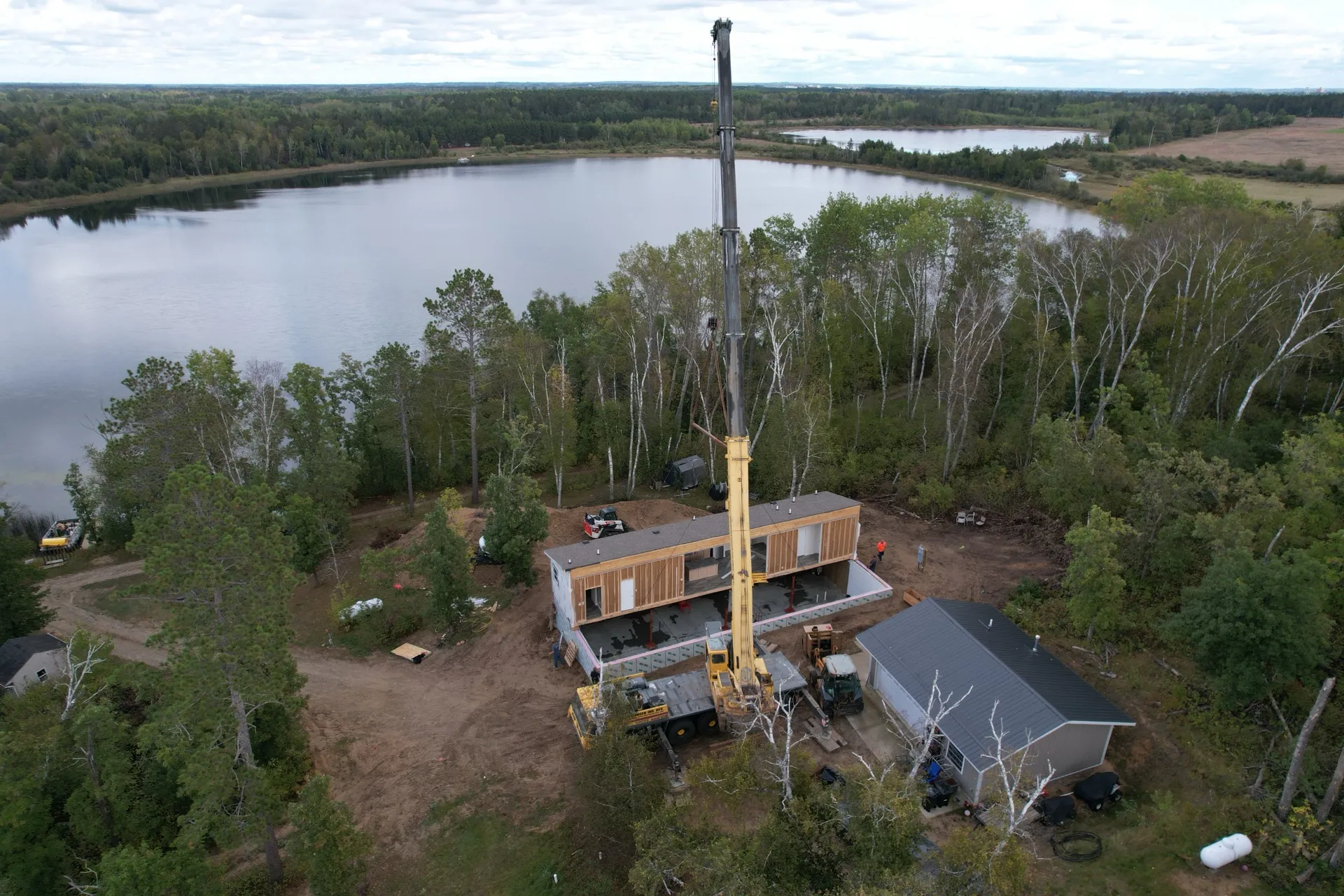 Aerial view of a lake home being set in place by a Christensen Crane near Bemidji, Minnesota.