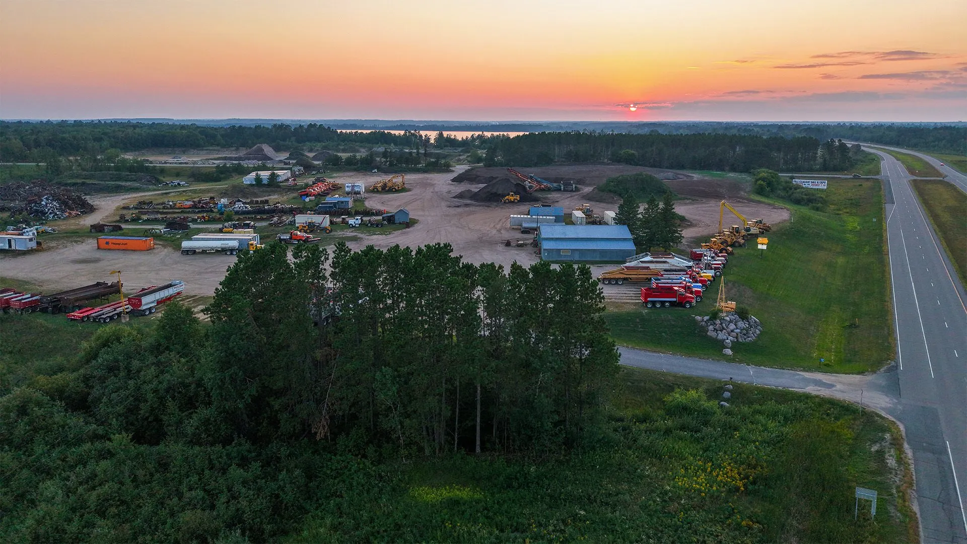 Aerial view of the Storlie Construction gravel pit and equipment yard on Highway 2 near Cass Lake, Minnesota, at sunset.